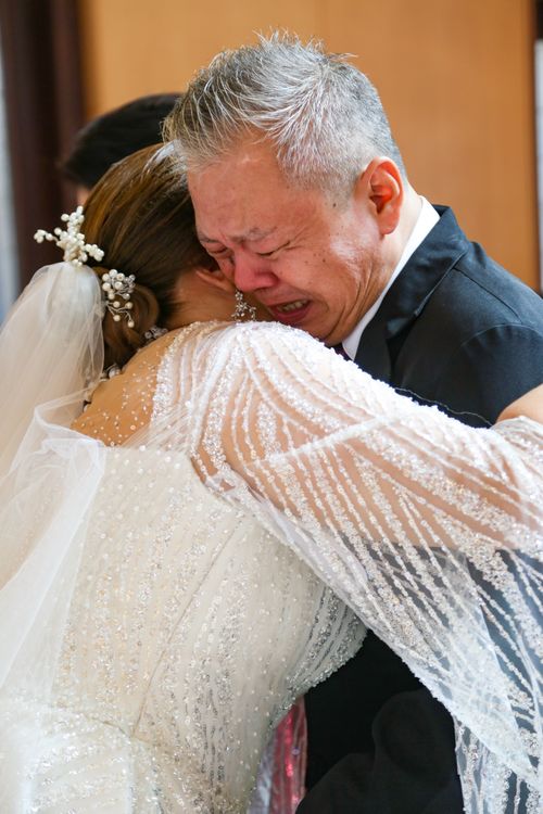 Free Heartfelt moment of a bride embracing her father during wedding ceremony. Stock Photo