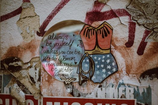 Colorful Wonder Woman graffiti with an inspiring message on a wall in Cologne, Germany.