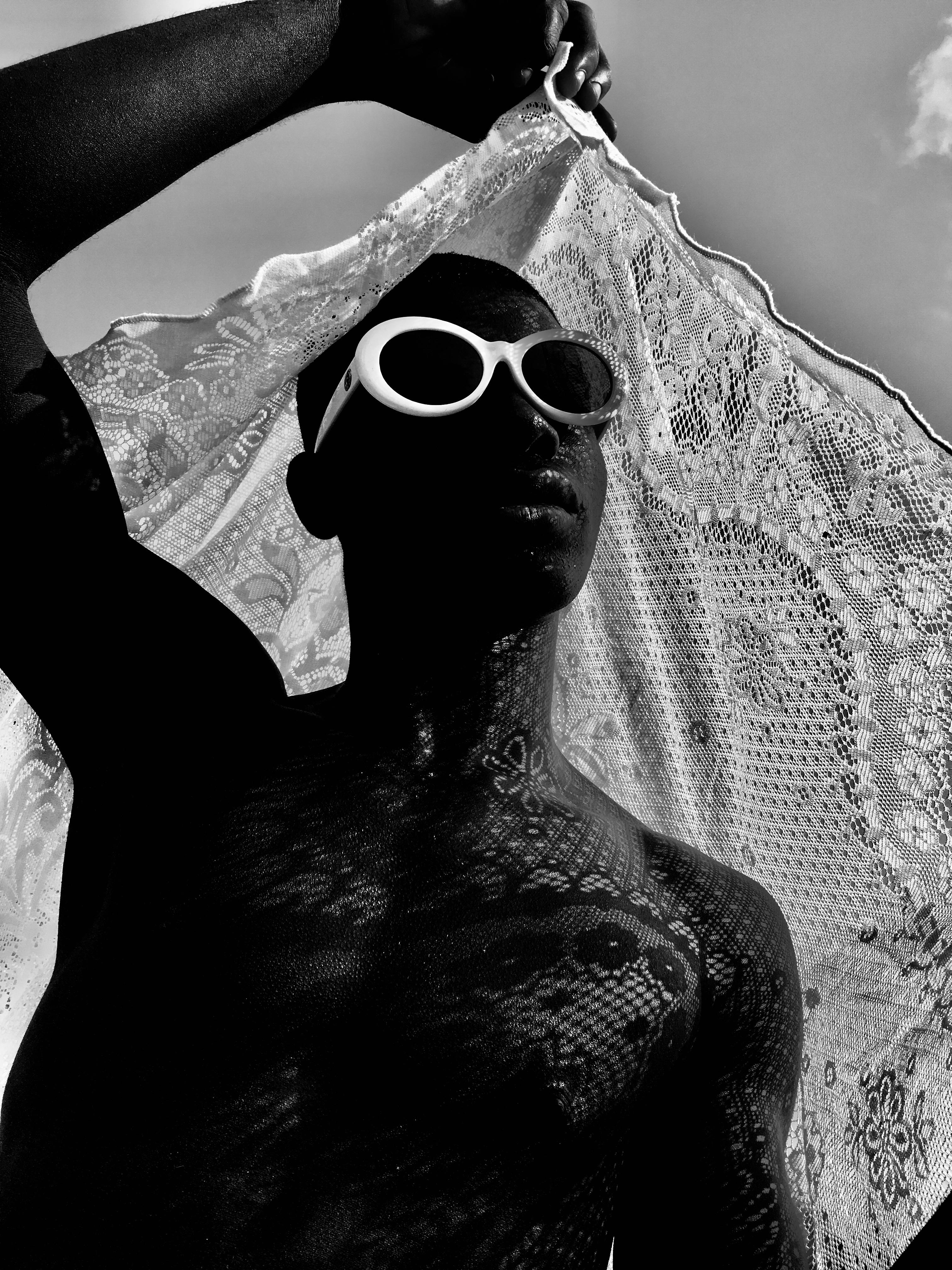 grayscale photo of man wearing sunglasses holding scarf