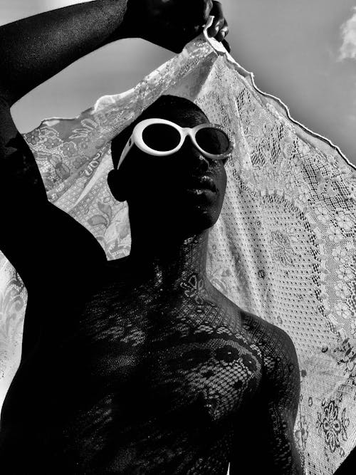 Grayscale Photo of Man Wearing Sunglasses Holding Scarf