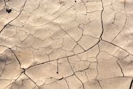 特写镜头中，开裂干燥的土地凸显出干旱贫瘠的景观