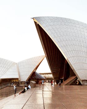 Stunning view of the Sydney Opera House with visitors enjoying the iconic landmark at dusk.