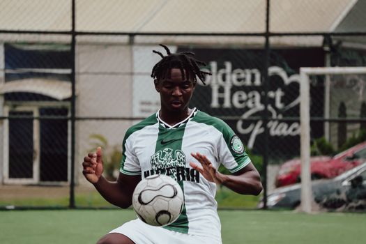 Young male soccer player on an outdoor field skillfully controlling the ball.