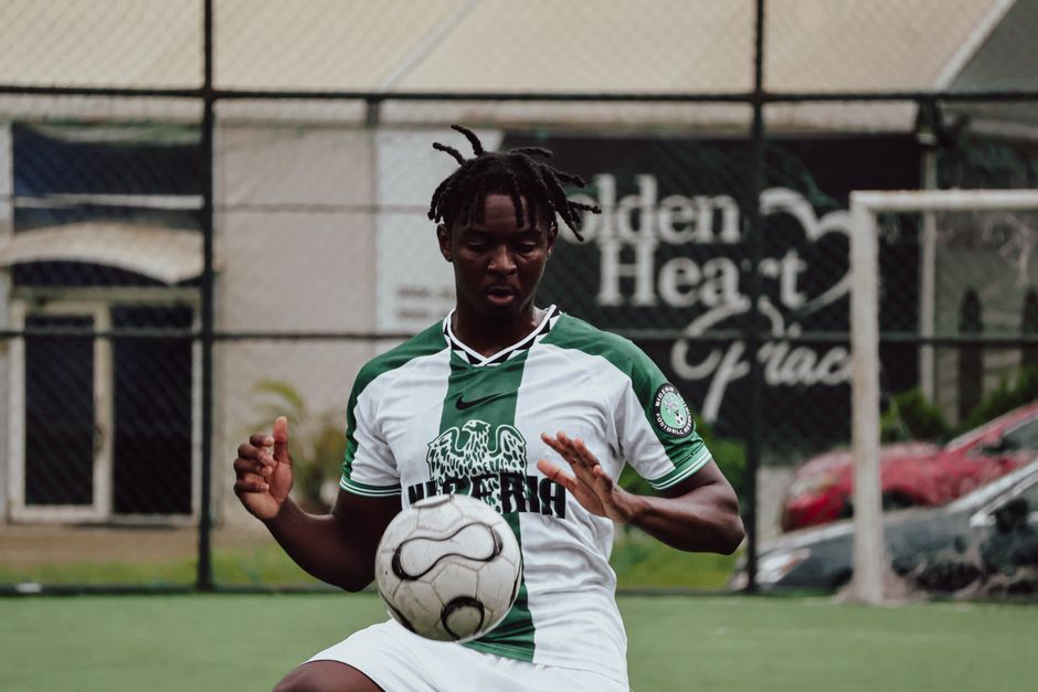 Young male soccer player on an outdoor field skillfully controlling the ball.