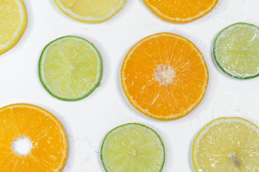 Colorful citrus slices including orange, lemon, and lime on a white background.