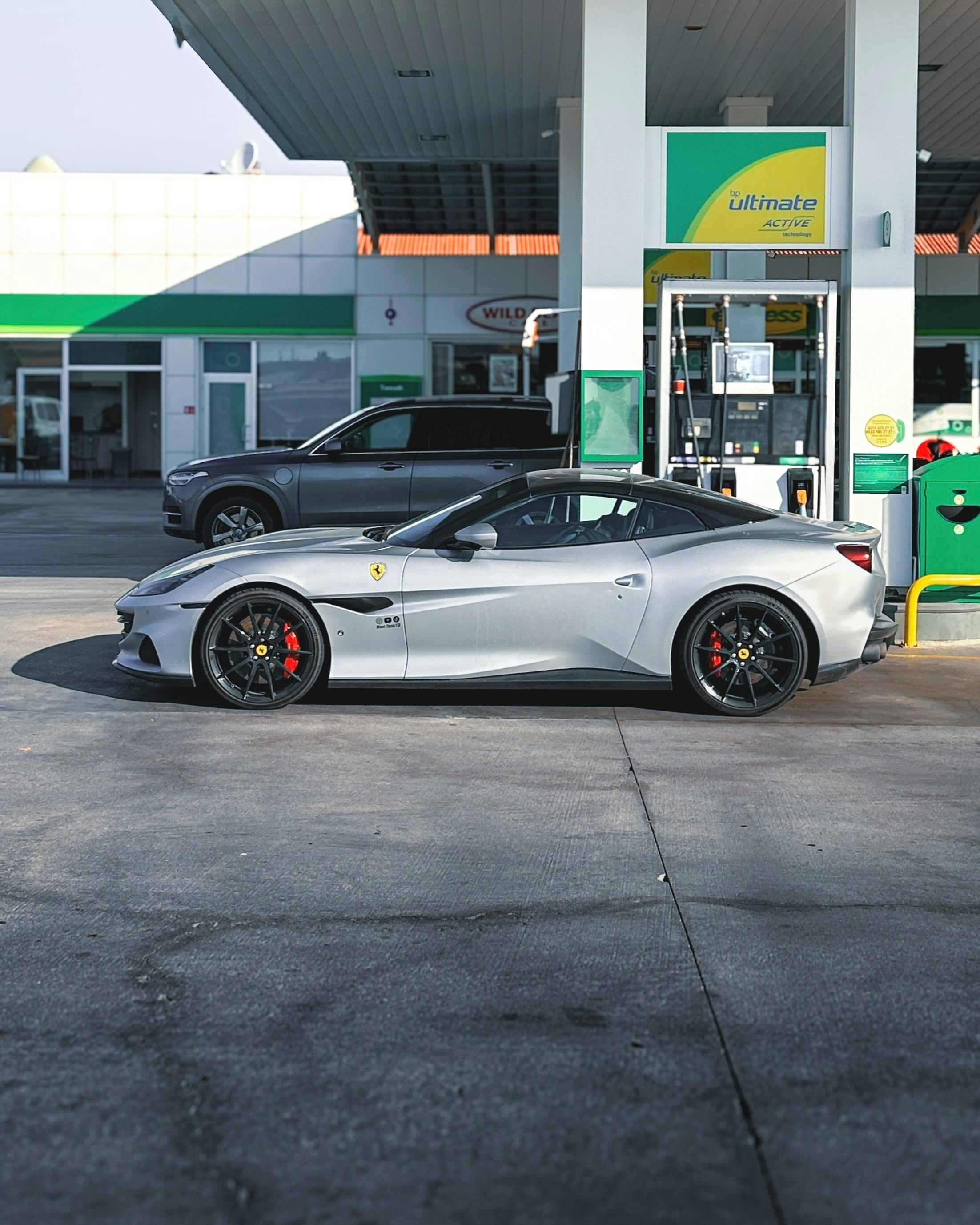 Silver sports car refueling at a gas station in Ankara, Türkiye, on a sunny day.