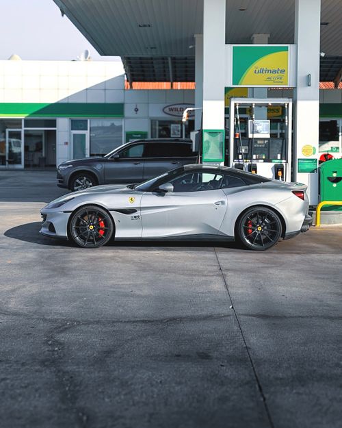 Free Silver sports car refueling at a gas station in Ankara, Türkiye, on a sunny day. Stock Photo