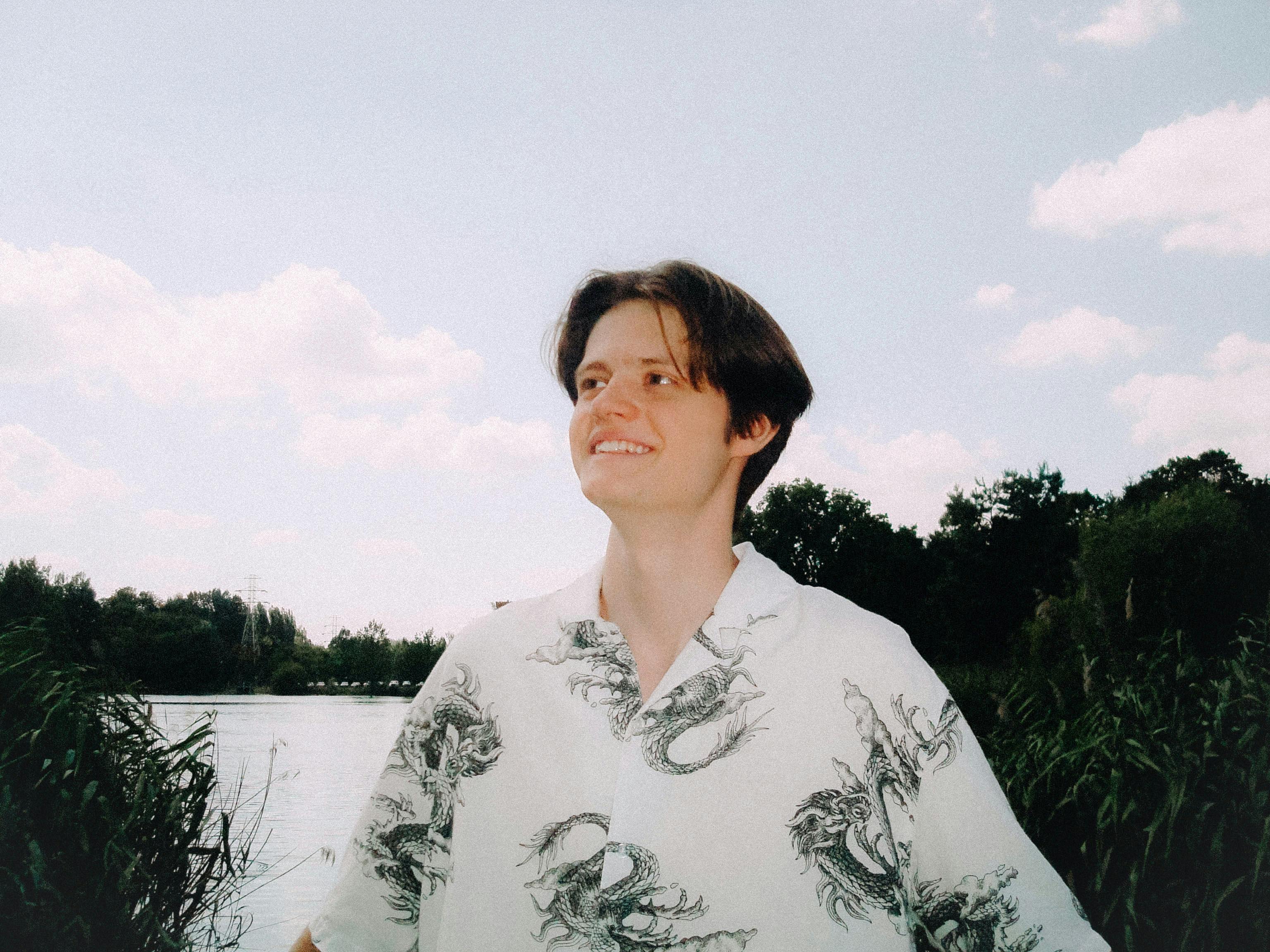 бесплатная Молодой человек наслаждается солнечным днем у реки в Лодзи, Польша. Стоковое фото