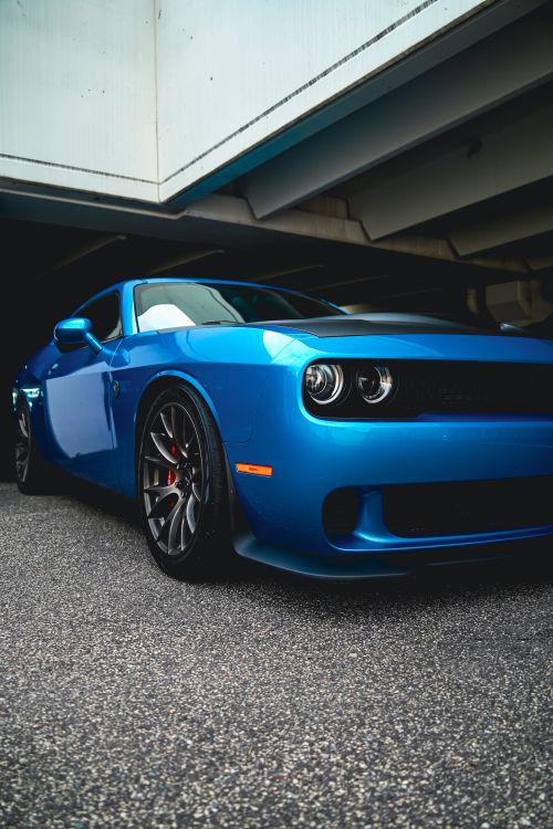 Free Stylish blue sports car parked under a city overpass, showcasing modern design. Stock Photo