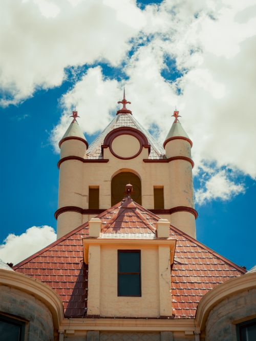 Free A tall, historic courthouse tower against a vibrant blue sky with white clouds in Brady, TX. Stock Photo