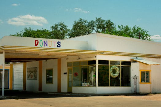 Vintage donut shop exterior in Brady, TX, on a sunny day, showcasing colorful signage and retro design.