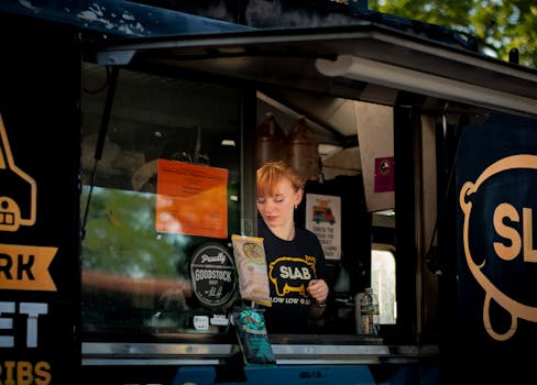 A female vendor serves from a food truck in Austin, TX.