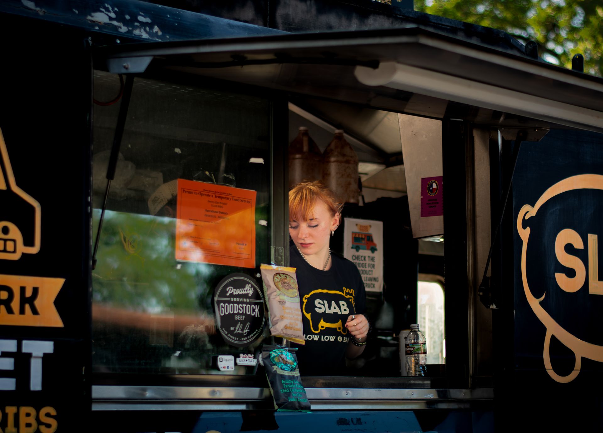 A female vendor serves from a food truck in Austin, TX.