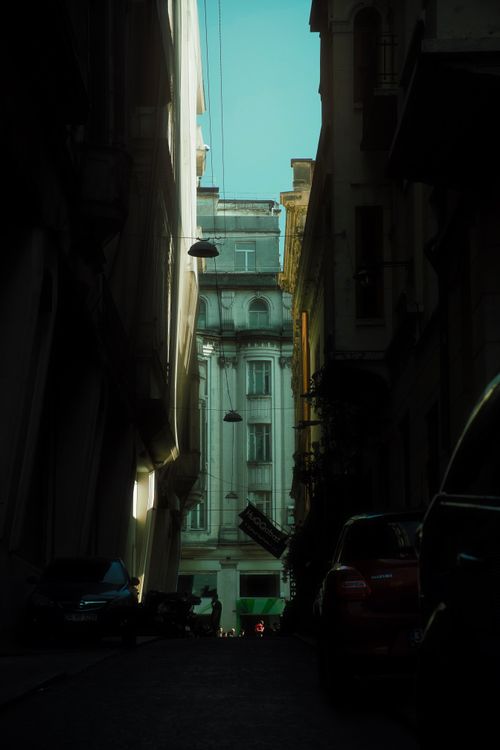 Free Dramatic view of a narrow urban alleyway leading to a historic building under daylight. Stock Photo