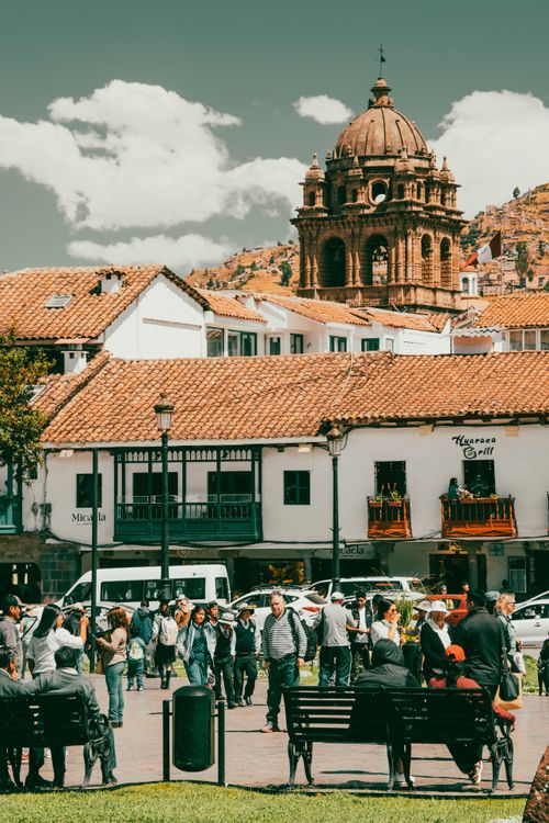 Free Crowds gather in a lively Cusco plaza surrounded by charming historical buildings and vibrant scenery. Stock Photo