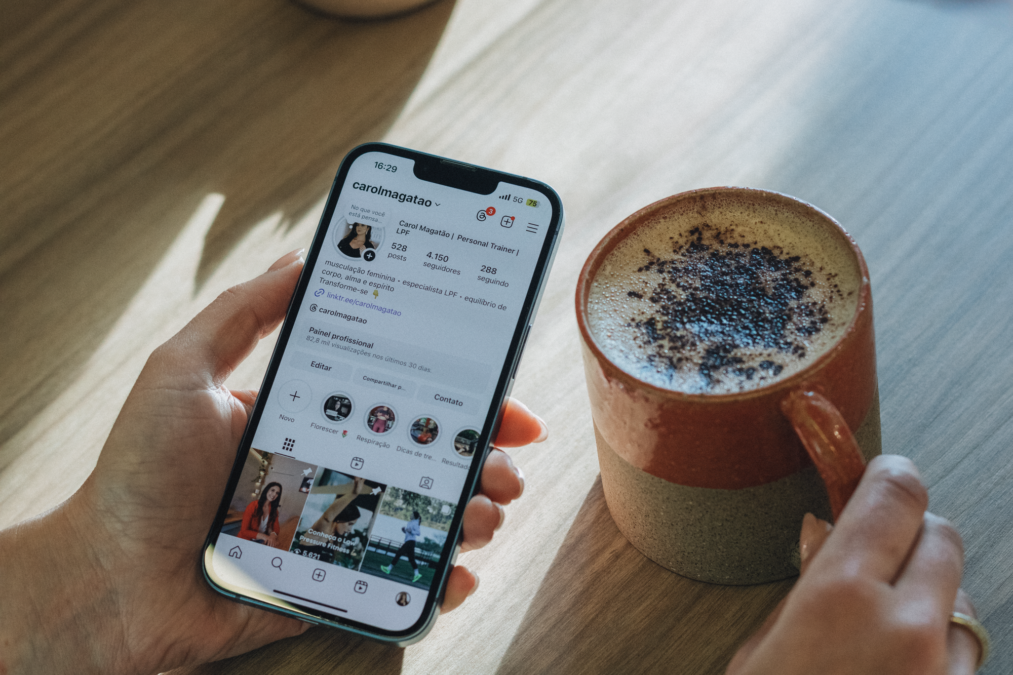 Persona sosteniendo un teléfono móvil con una aplicación de redes sociales abierta