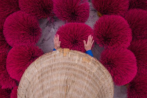 Free Hands crafting incense sticks in a vibrant traditional setting. Stock Photo