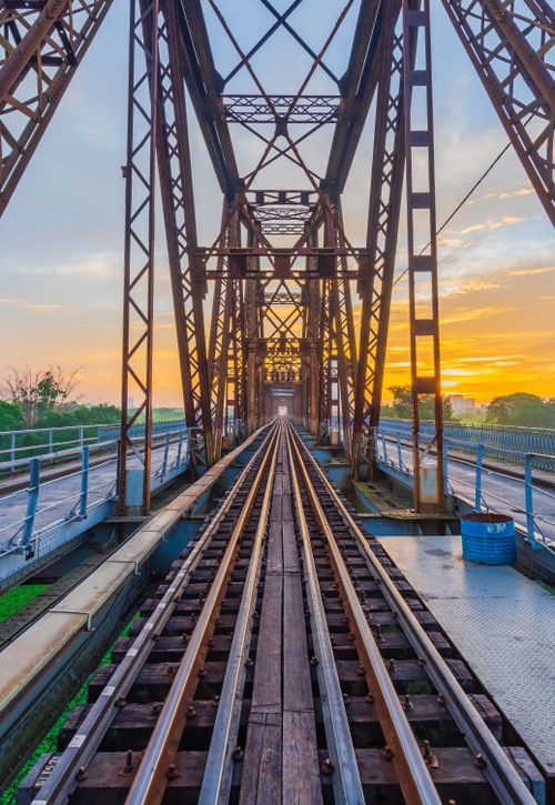 Free A scenic view of a rustic iron bridge at sunset, showcasing vibrant colors and strong architectural lines. Stock Photo