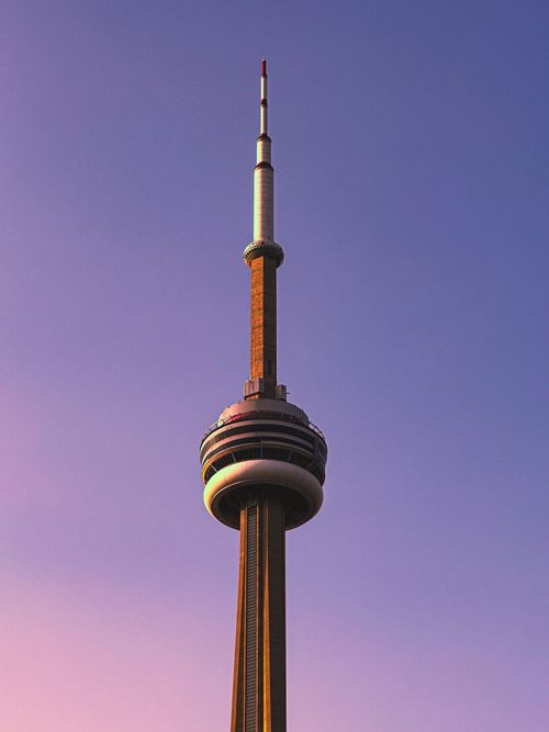 Free Iconic CN Tower stands tall with a vibrant sunset backdrop in Toronto, Canada. Stock Photo