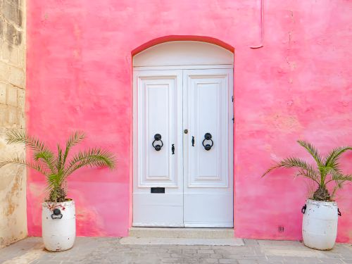 Free Explore a vibrant pink facade with a classic white door in Malta's historic streets. Stock Photo