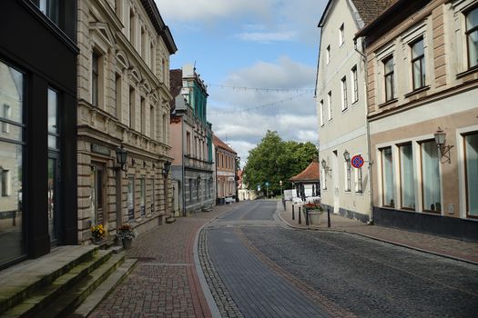 A picturesque cobblestone street lined with historic European buildings, bathed in daylight.