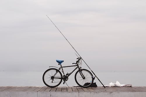 Angelrute Und Schwarzes Fahrrad Auf Betonboden