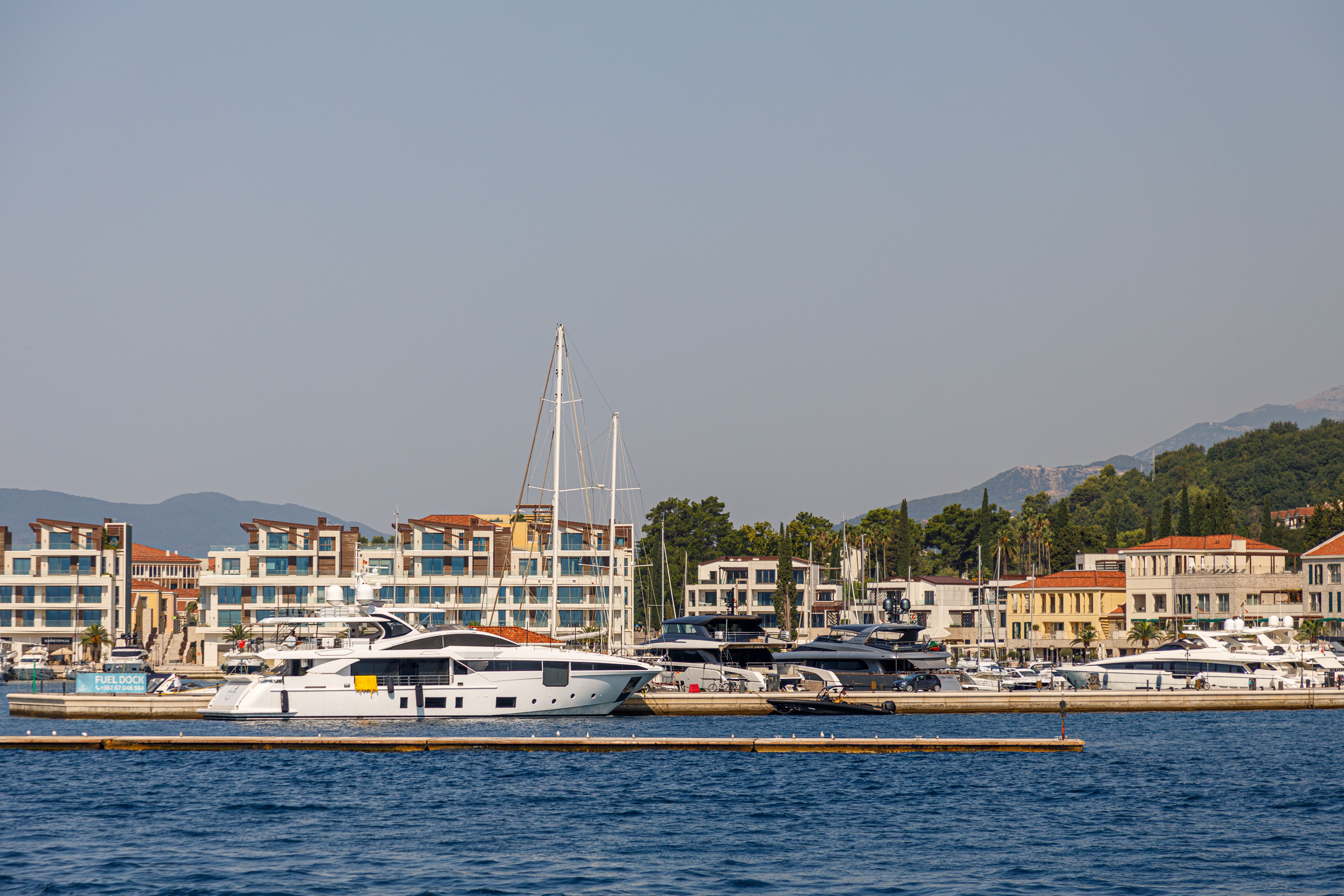 A minimalist composition of a luxury yacht and private jet, symbolizing integrated asset management and fiduciary oversight.