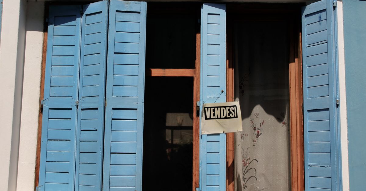 Elegant blue shutters on a Venice building with a 'For Sale' sign, capturing classic Italian charm.