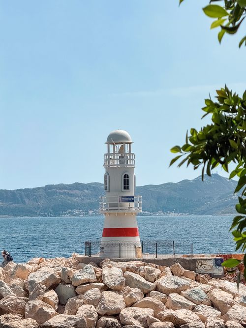 Free A picturesque lighthouse stands by the sea with a mountainous backdrop in Kaş, Türkiye. Stock Photo