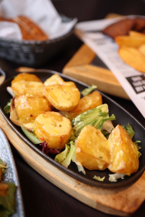 Free Close-up of roasted potatoes on a bed of fresh greens, perfect for a healthy meal. Stock Photo