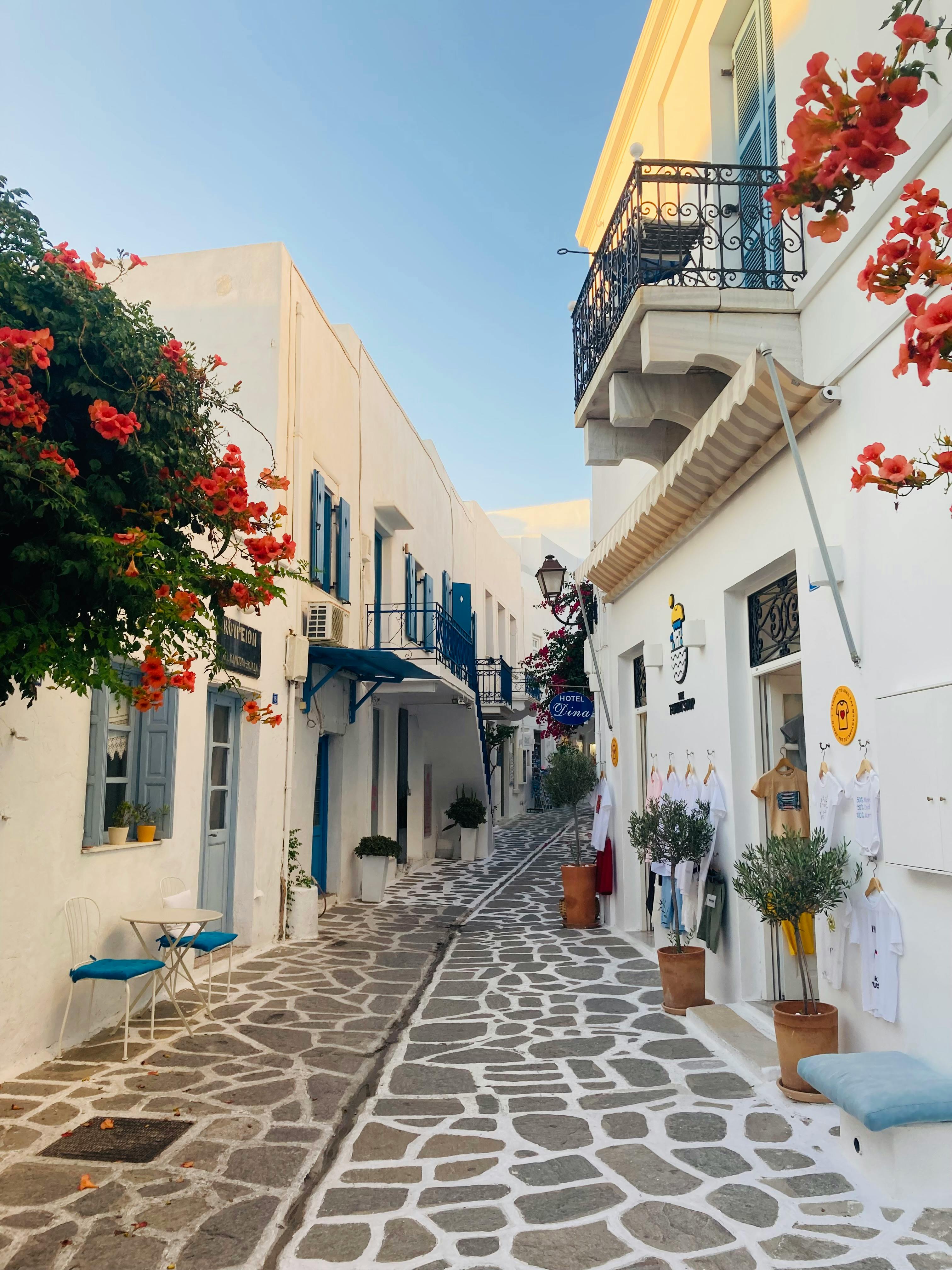 Picturesque narrow street in Parikia, Paros with vibrant flowers and traditional architecture.