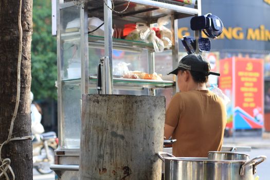 A local vendor prepares food at a street stall in bustling Ho Chi Minh City, Vietnam.