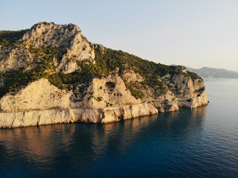 Breathtaking drone capture of Ligurian cliffs meeting the Mediterranean Sea.