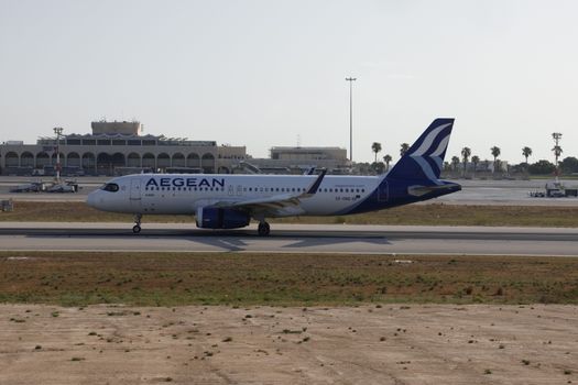 Aegean Airlines Airbus A320 taxiing on a sunny runway at airport.