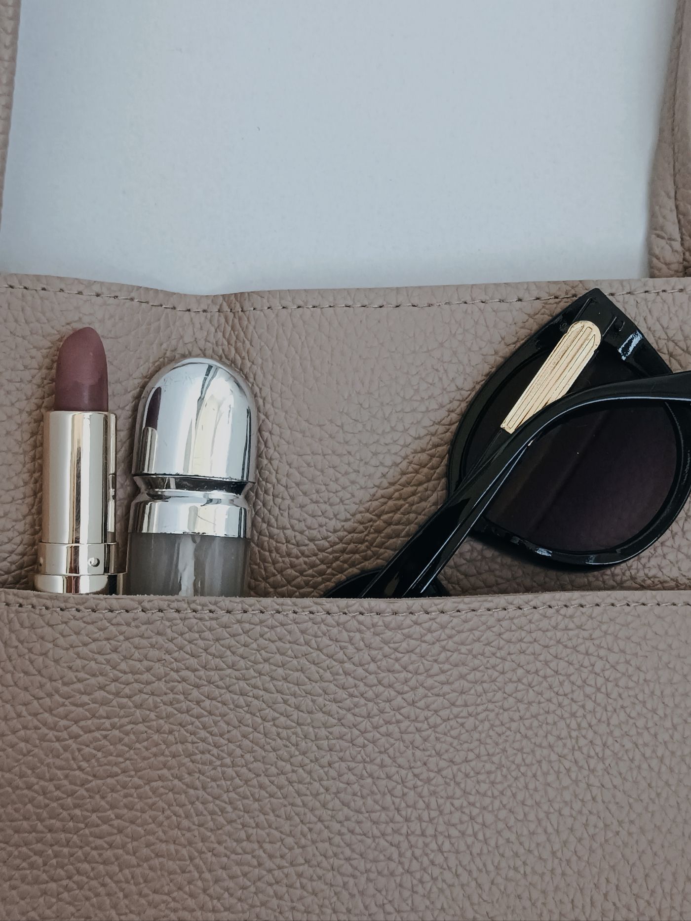 Beige handbag containing everyday accessories