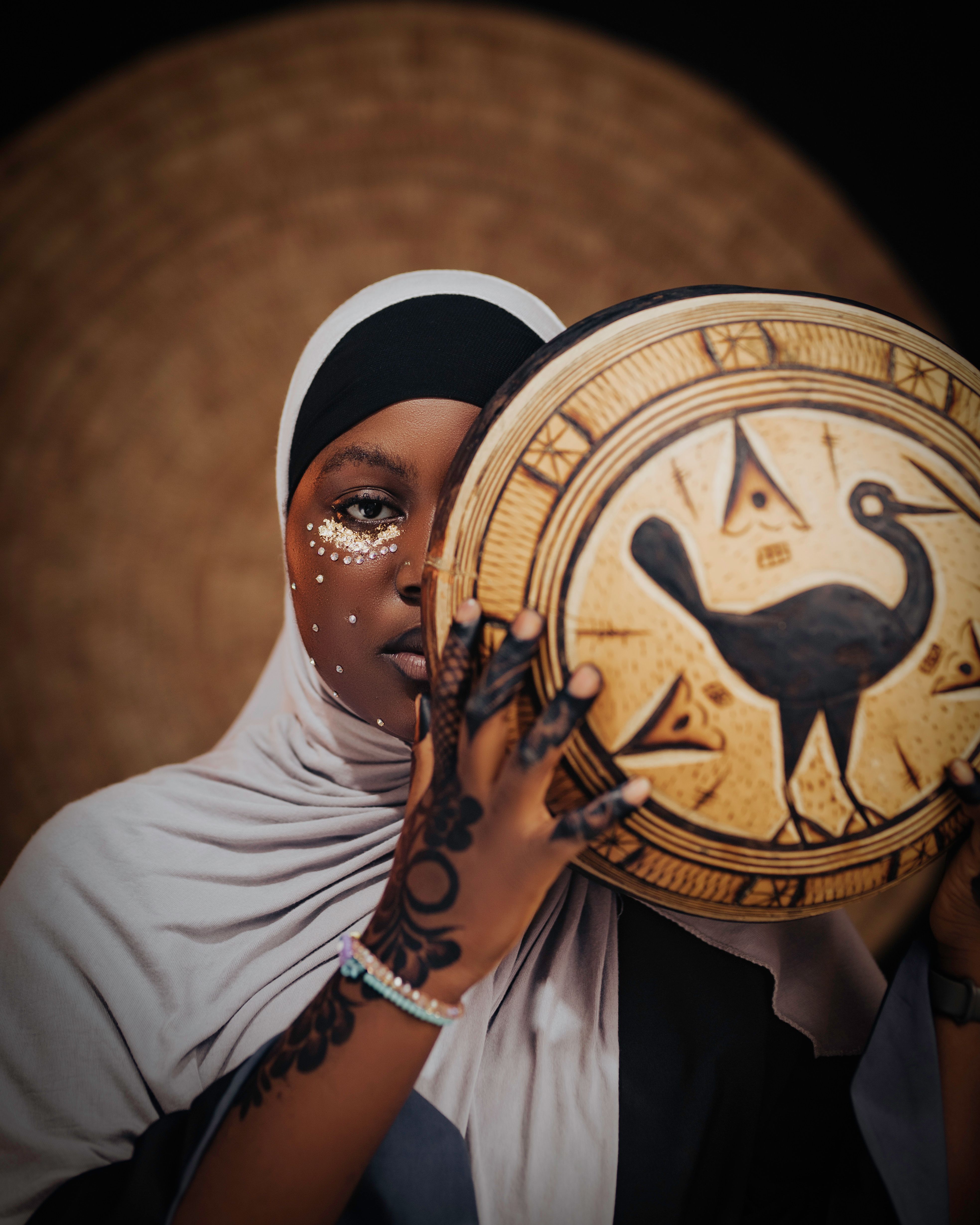Portrait of an African woman holding a traditional drum. Captured in Kano, Nigeria. Symbolic artistry and cultural expression.