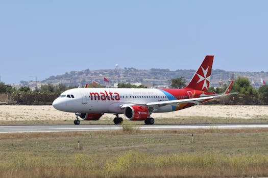 Air Malta plane taxiing on a runway at an airport during a sunny day.