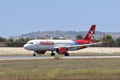 Free Air Malta plane taxiing on a runway at an airport during a sunny day. Stock Photo