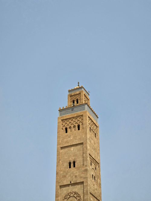 Free A stunning view of a historic minaret tower reaching into a clear blue sky, showcasing intricate architectural details. Stock Photo