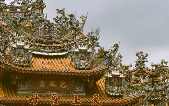 Detailed view of traditional Taiwanese temple architecture with ornate sculptures in Pingtung, Taiwan.