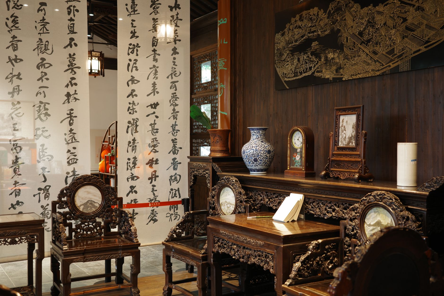 Traditional Chinese room with ornate furniture and calligraphy screen, offering a serene and historical ambiance.