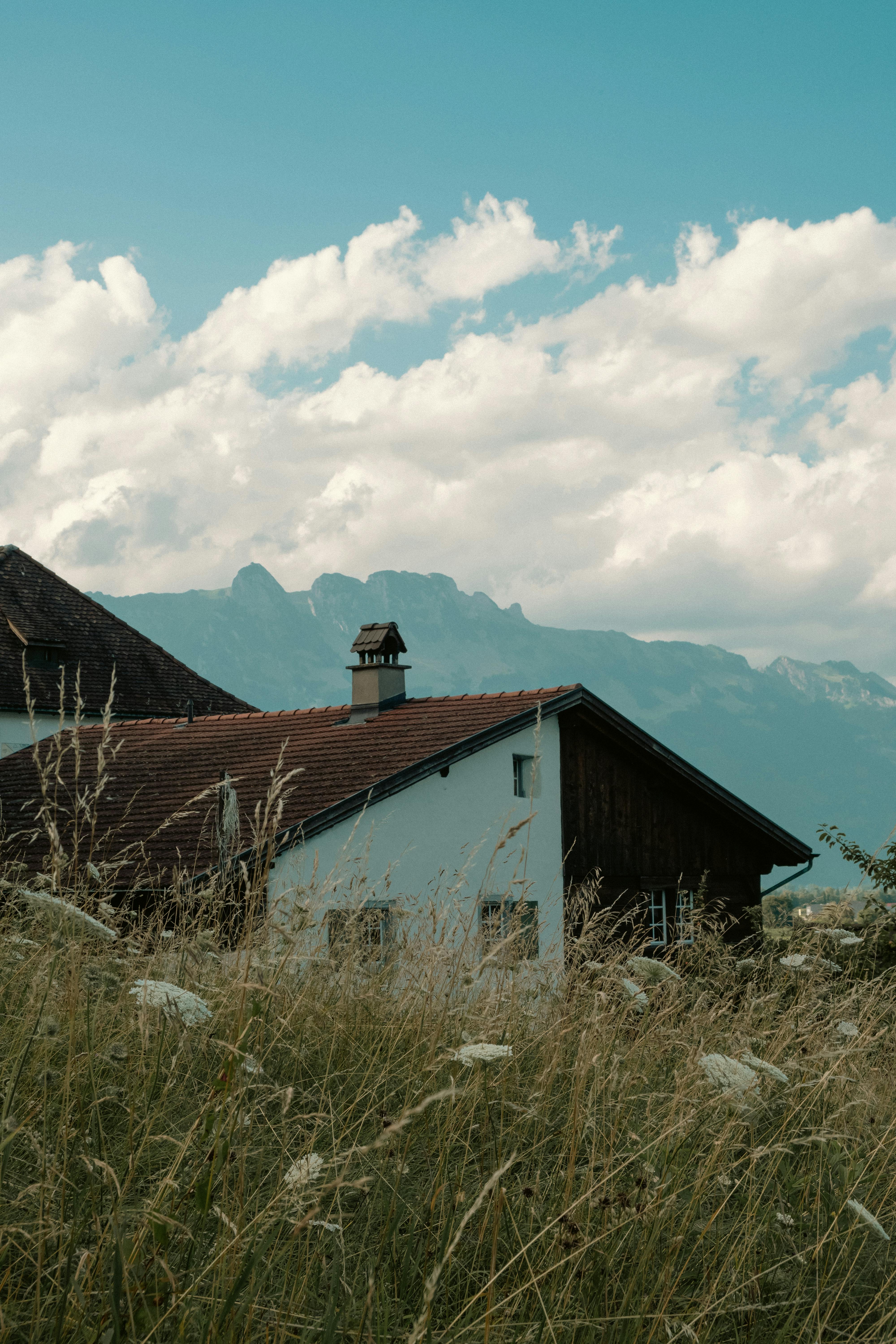 Charming alpine house in Switzerland with a breathtaking view of the mountains and clear summer skies.