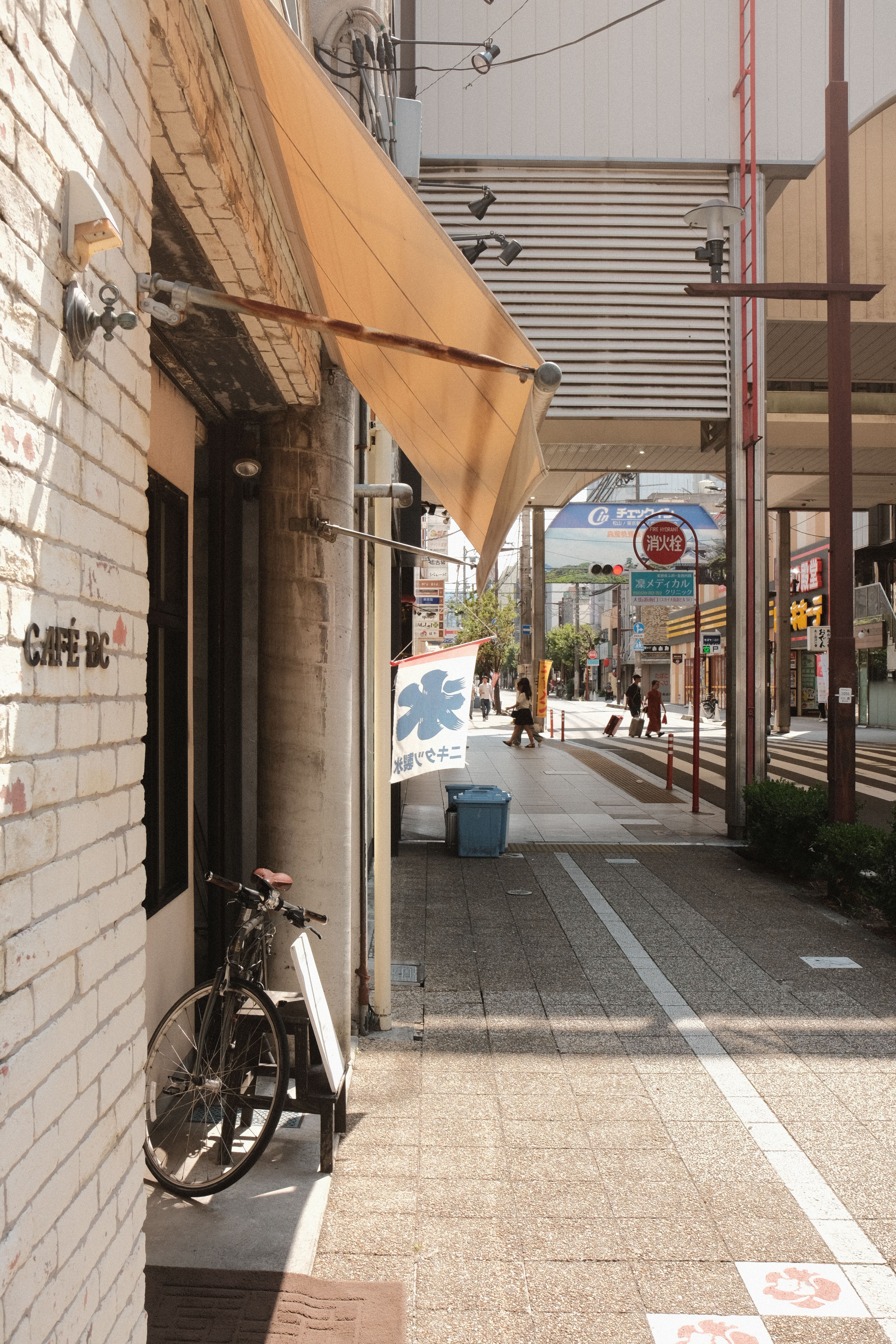 Sunlit street featuring a vintage cafe and bicycle, capturing a charming urban vibe.