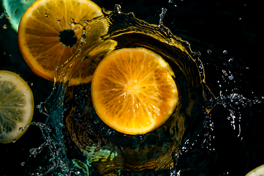 Dynamic citrus fruits create a vibrant splash in water, capturing freshness and energy.