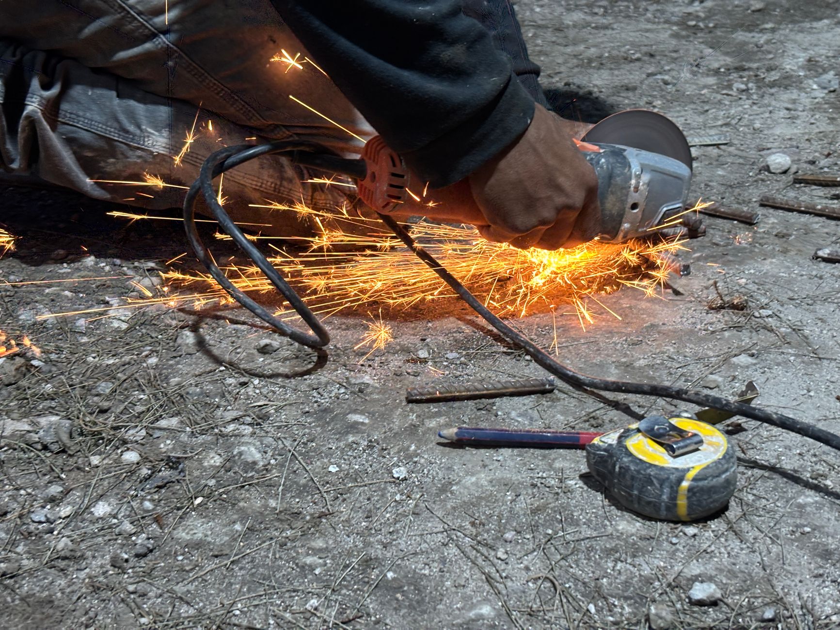 Angle grinder in action with bright sparks, showcasing metalwork at night.