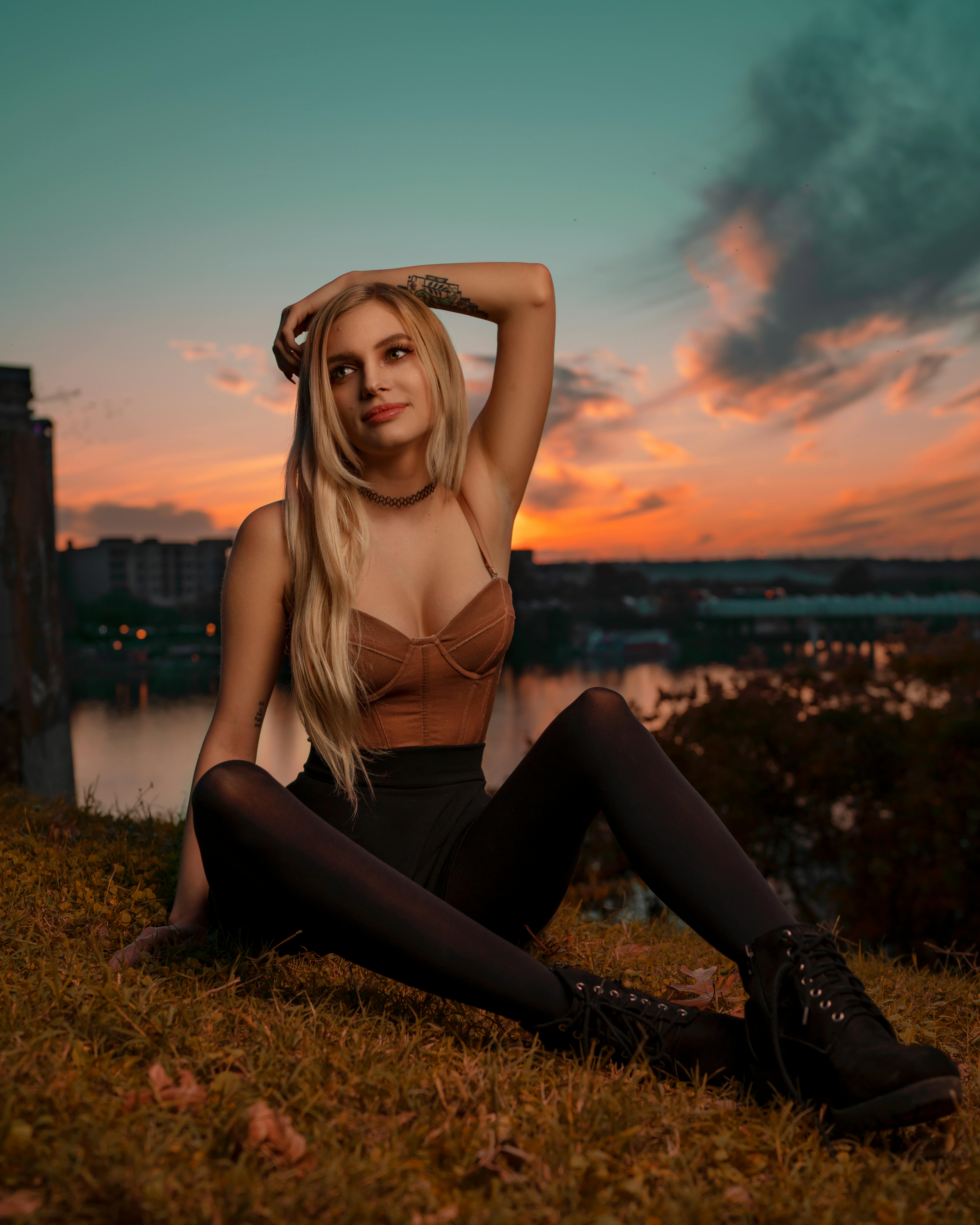 在德克萨斯州奥斯汀的湖边，一位时尚的女人在令人惊叹的日落时分摆出姿势，散发着美丽与自信