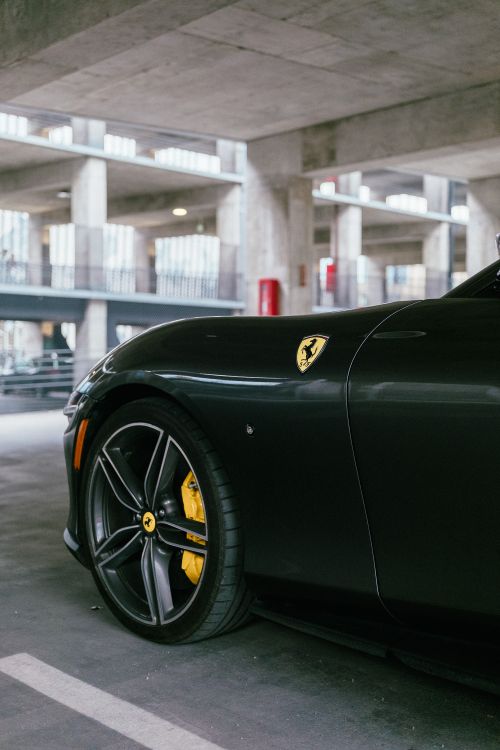 Free Close-up of a luxury black sports car parked indoors, highlighting its sleek design and branding. Stock Photo