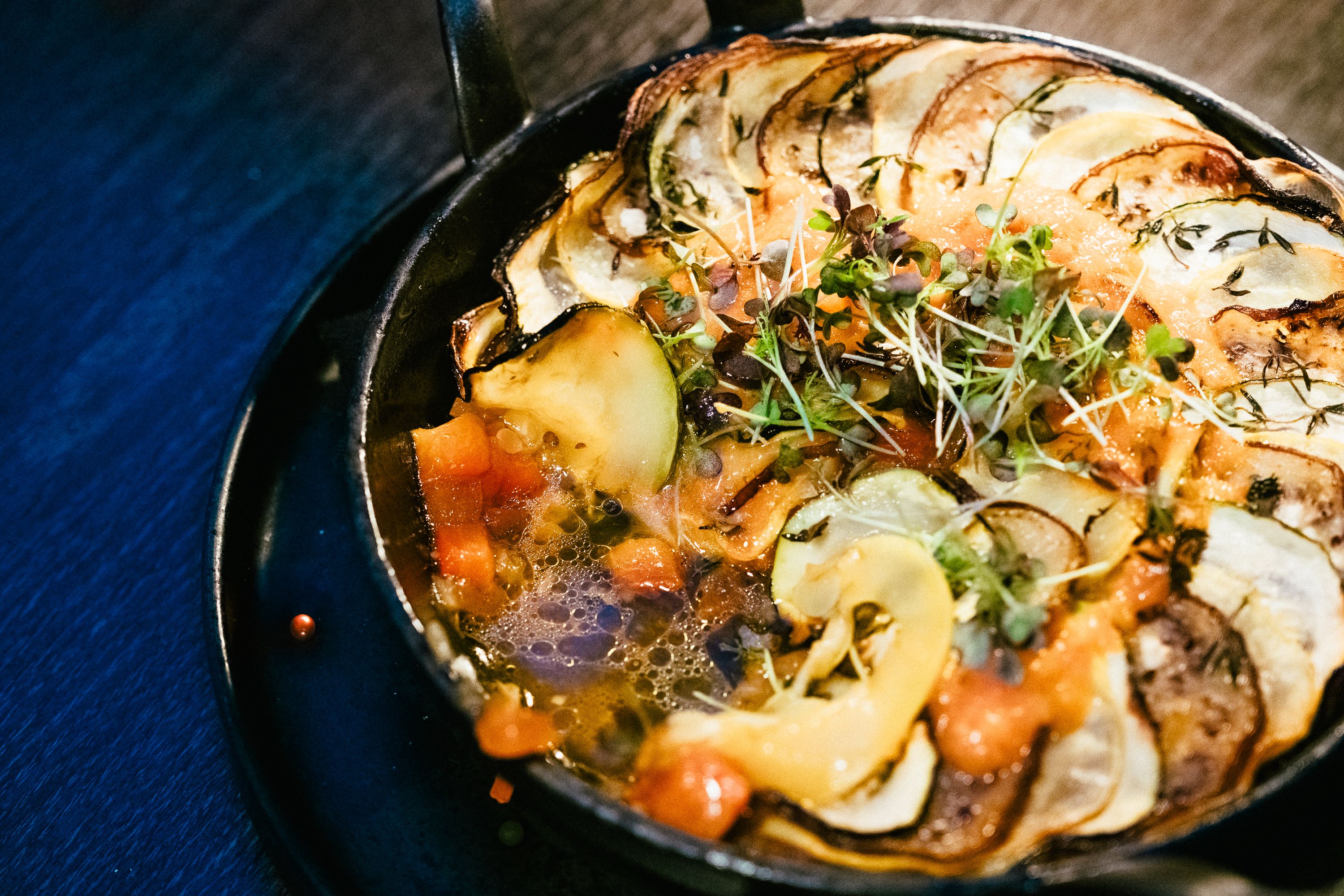 Gratis Un piatto gourmet di ratatouille vivace, cucinato in una padella nera, perfetto per esperienze gastronomiche raffinate. Foto a disposizione