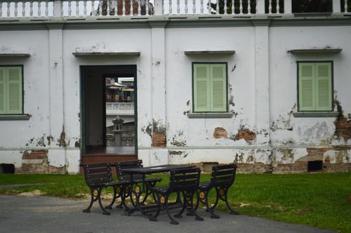 Free Abandoned historic building with wooden benches outside, showcasing decay and heritage. Stock Photo