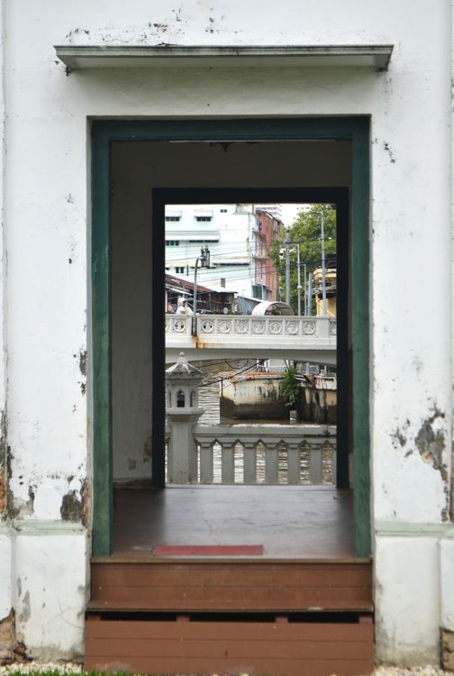Free Weathered doorway frames a view of buildings and a bridge, downtown setting. Stock Photo